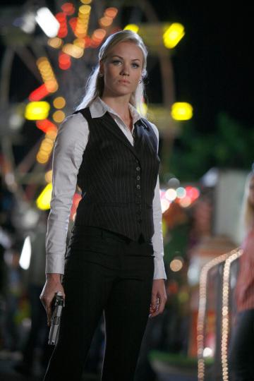 Yvonne Strahovski  in black pinstriped pants suit with gun