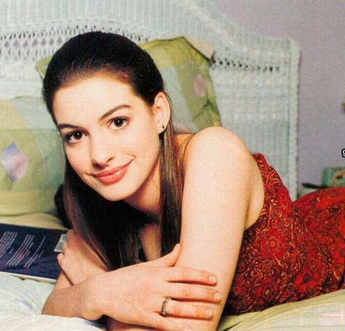 Anne Hathaway lying on a bed in red paisley