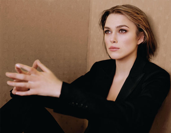Keira Knightly looks pensive leanign up against a wall
