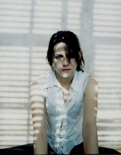 Kristen Stewart in the shadows in a white shirt