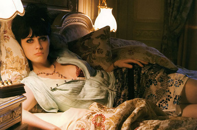Zooey Deschanel gives us a come hither look while lying on a bed